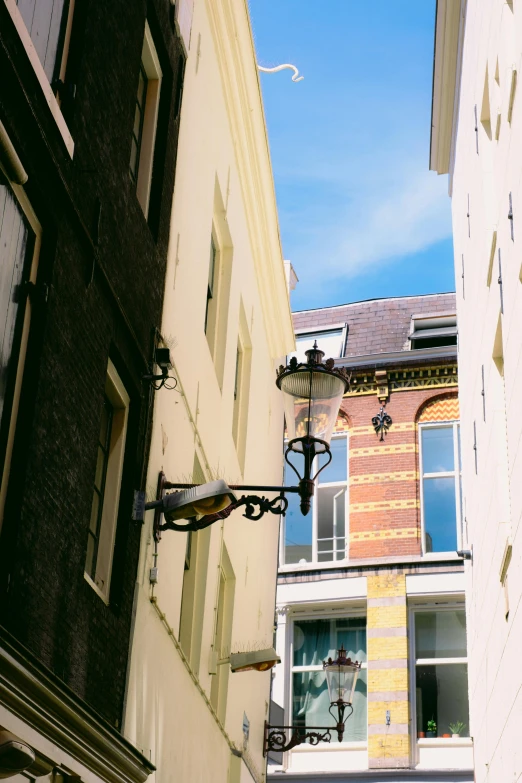 an old fashioned street light and buildings against a blue sky