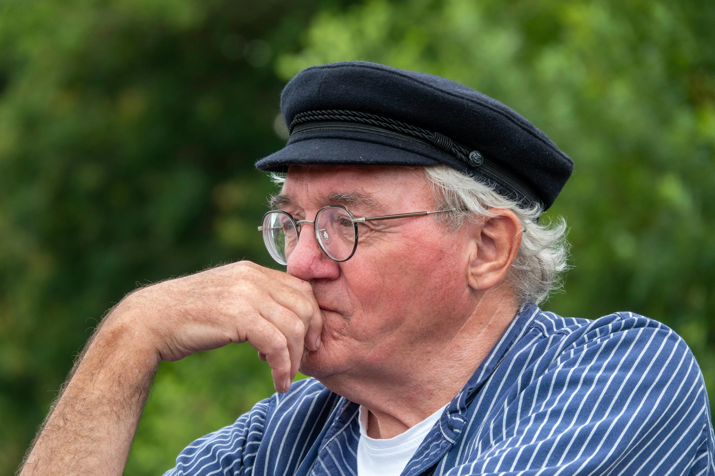 an elderly man in blue  shirt and hat with glasses