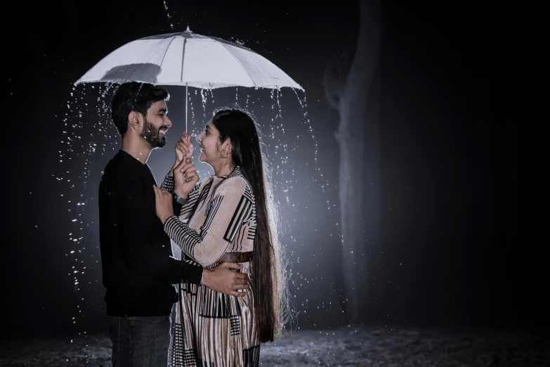 a young couple hugging under an umbrella on the rain