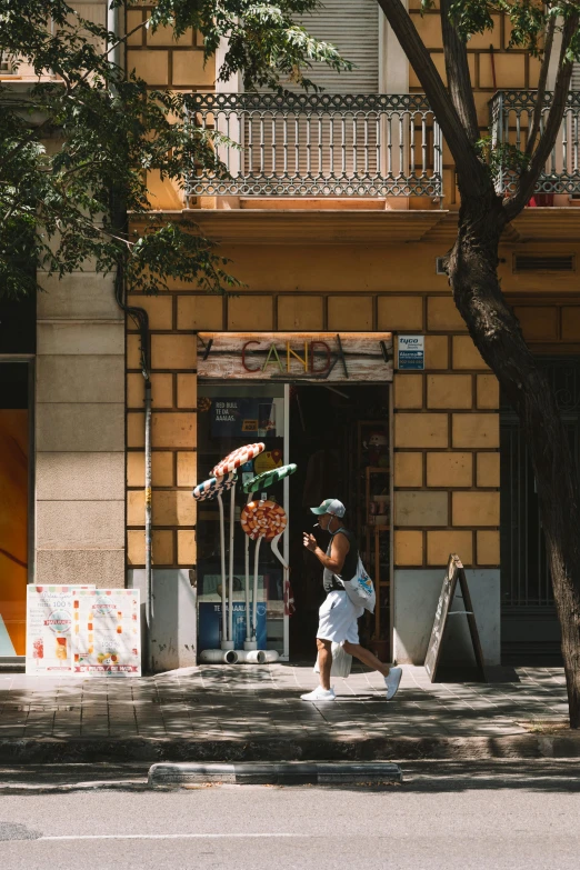 a woman running down a sidewalk next to an orange building