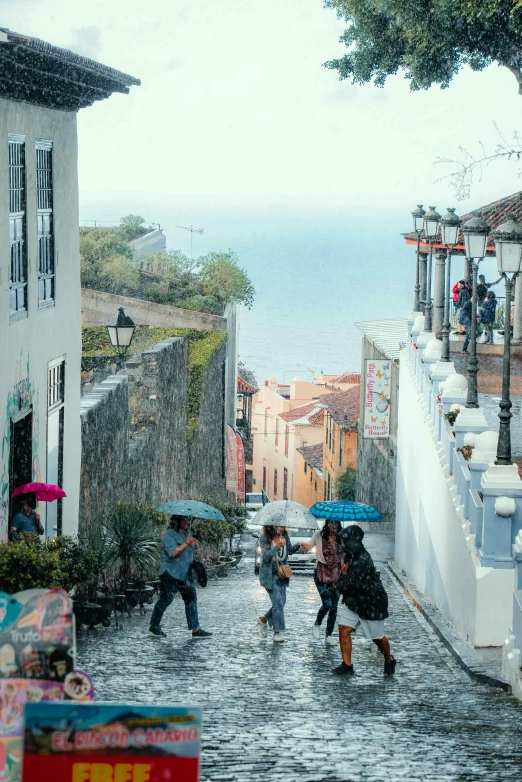 people walking on a cobblestone street during the day