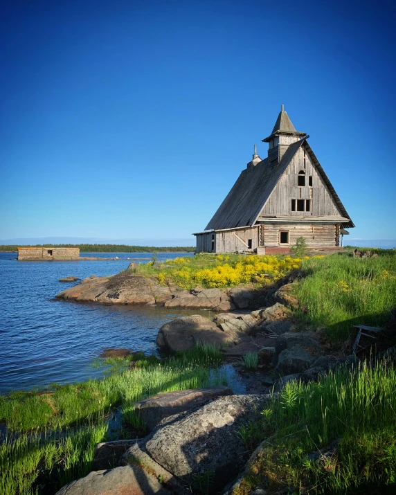 an old wooden house near the water on the shore