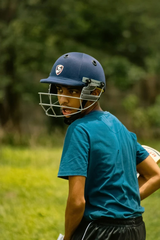 a  wearing a batting helmet and a catcher's mitt