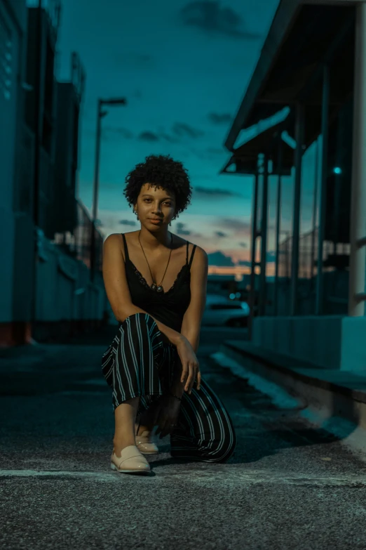 a woman sitting down and waiting on the side walk