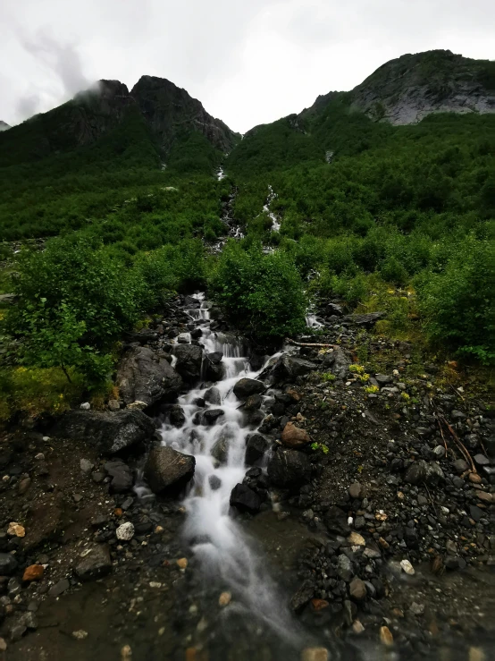 a small waterfall is seen in the middle of the hills