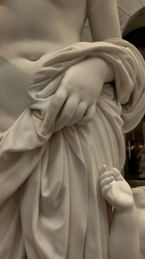 the statue features hands and feet holding a baby