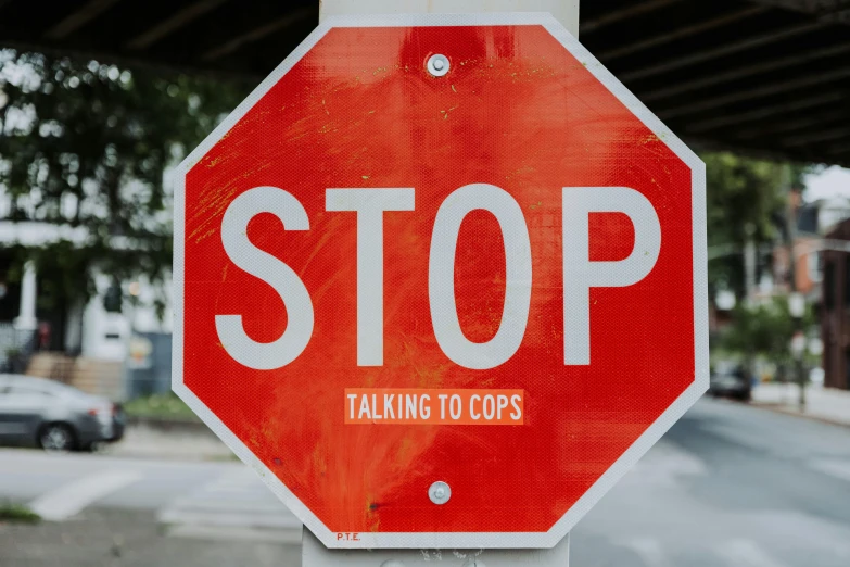 there is an orange and white stop sign with a sticker on it