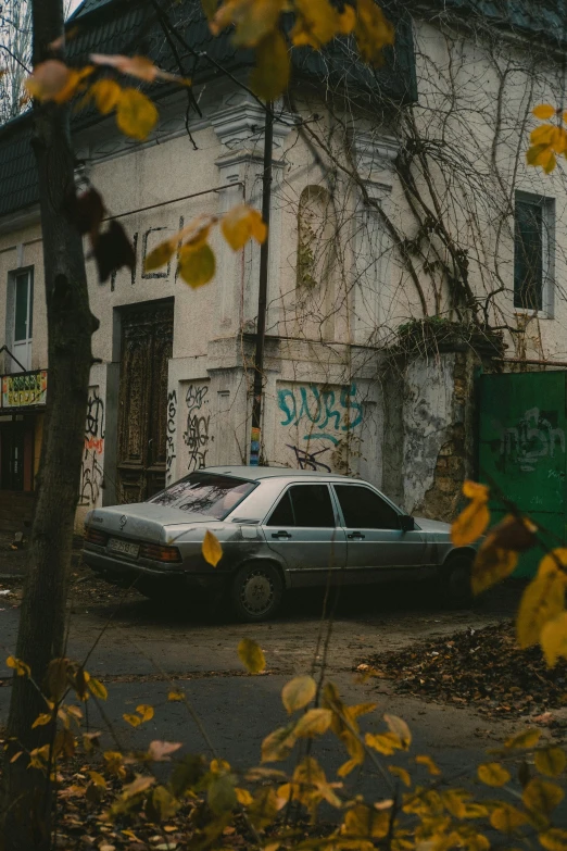 a car sitting on the road by an abandoned building