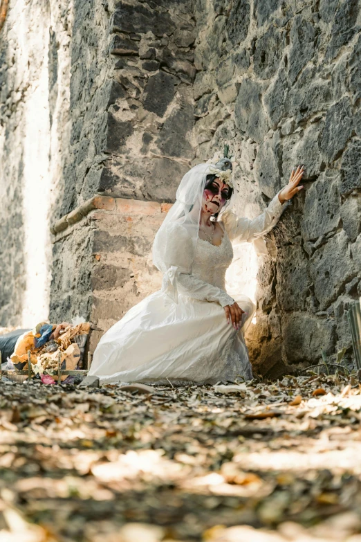 a woman in white dress and hat standing next to a wall