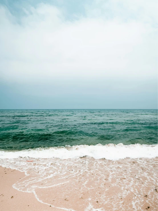 two umbrellas on a beach with waves and the water