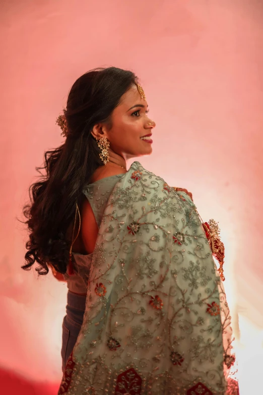 a women with long hair wearing jewelry and an ethnic gown