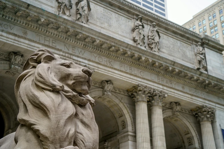 the lion head is next to the building's stone facade