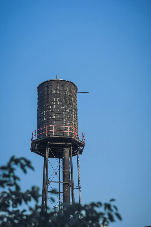 a tall water tower with a blue sky background