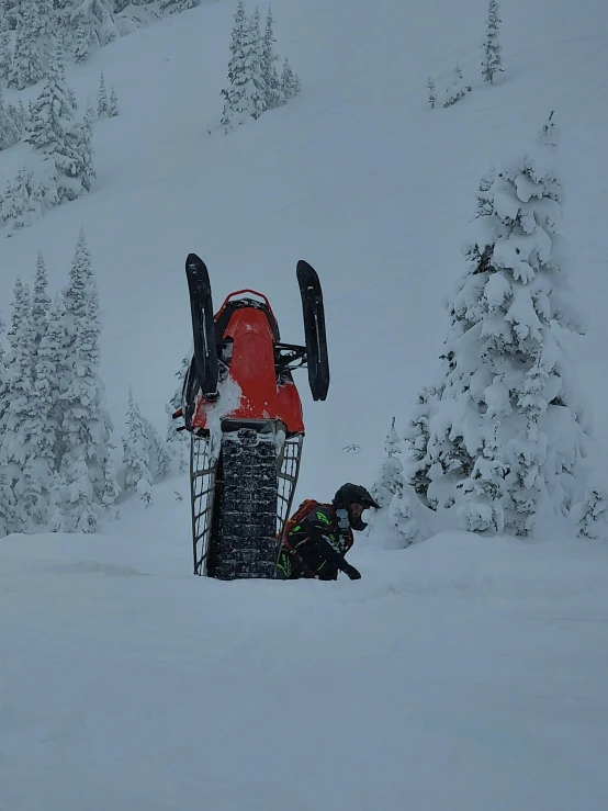 person climbing up to the top of their skis in the snow