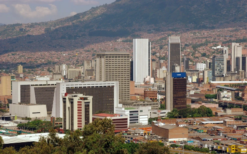 a city with skyscrs in the distance and mountains in the background