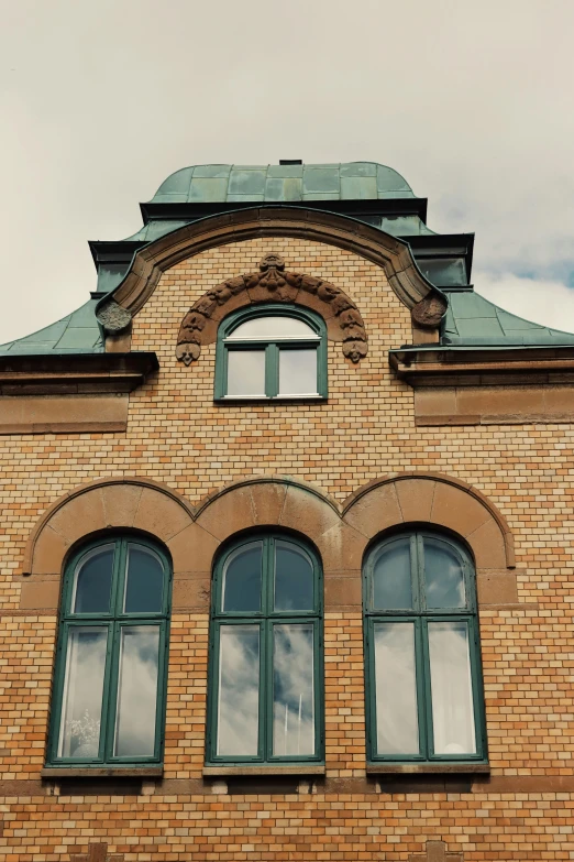 the front side of a brick building showing arched windows