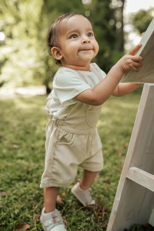 a young child is standing by a wooden board