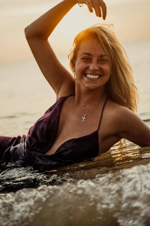 a beautiful blonde woman sitting in the water