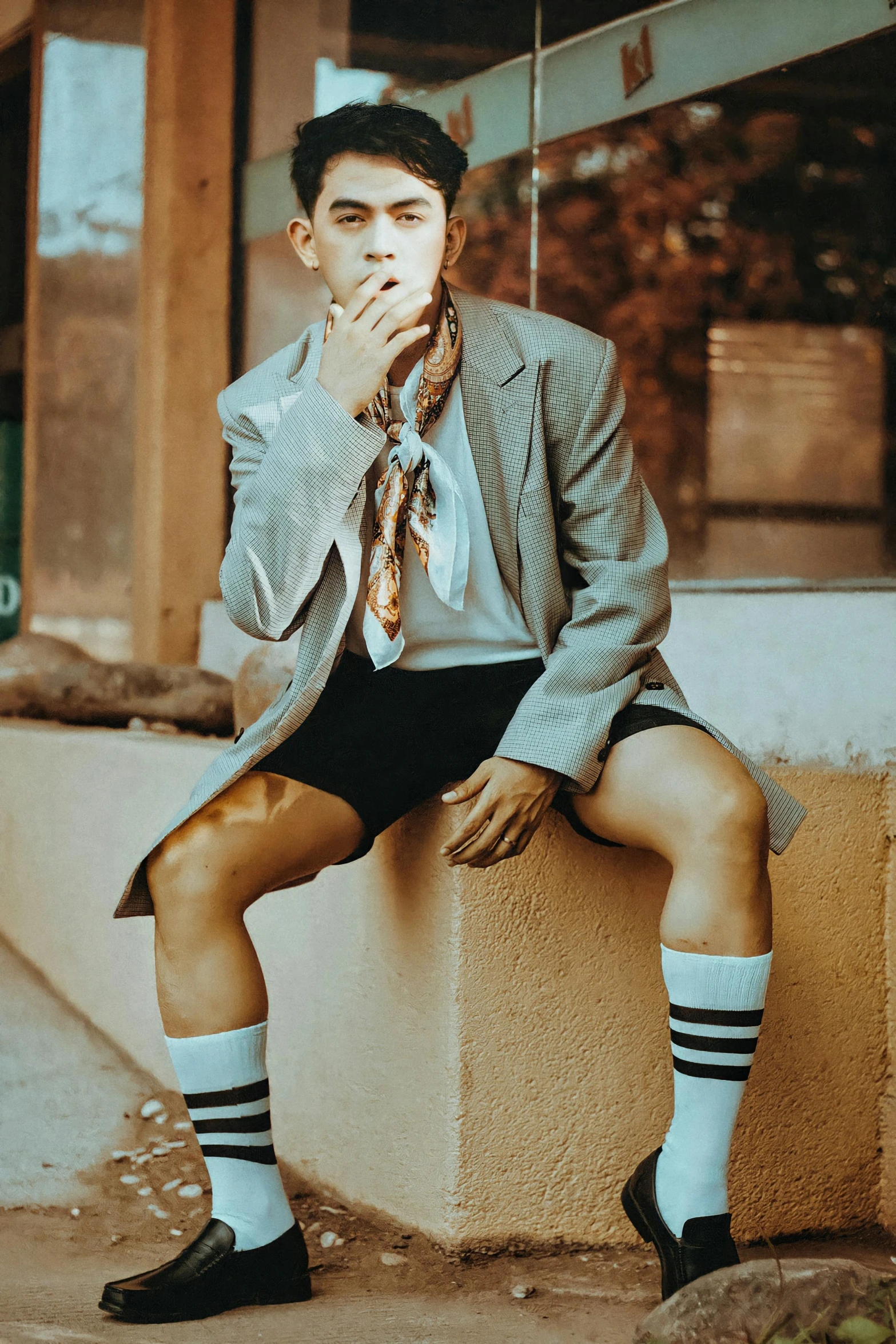 a man smoking a cigarette wearing shorts and socks