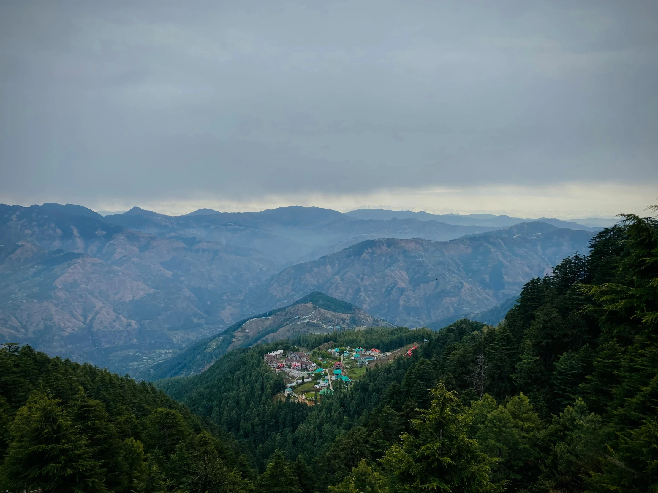 the mountains surrounding an apartment are covered by dense, green foliage