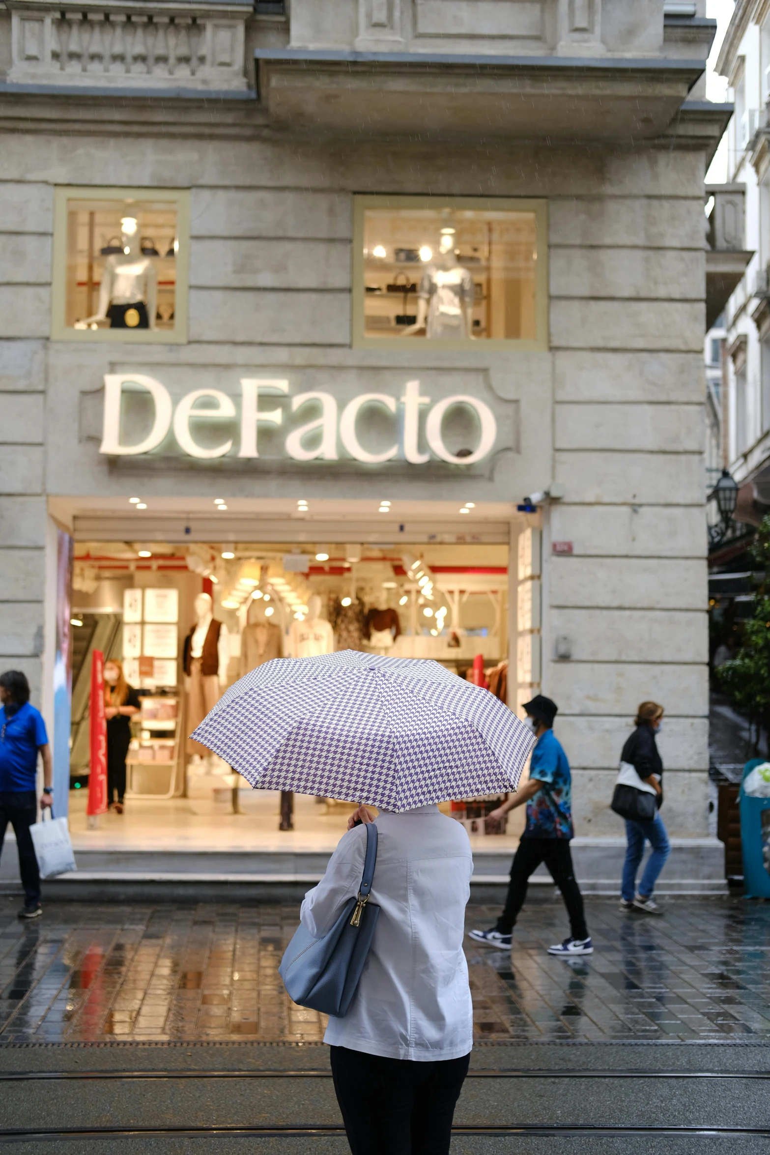 a person with an umbrella walking down the sidewalk