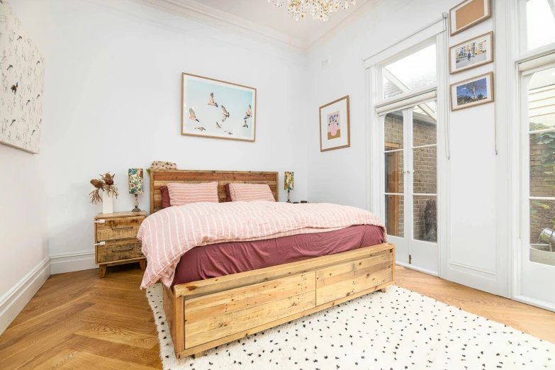 the bedroom features hardwood floors and white walls