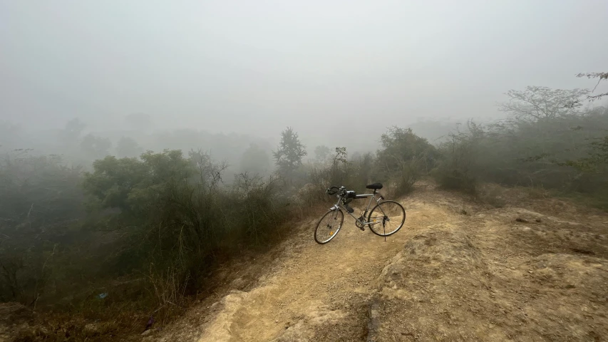 a bike leaning on the side of a dirt road