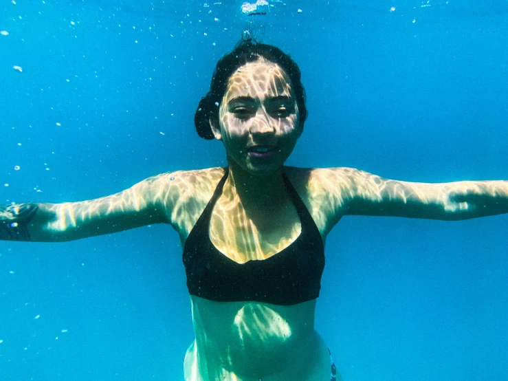 a woman that is standing up underwater in a pool