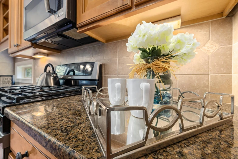 there is a vase with white flowers on the kitchen counter