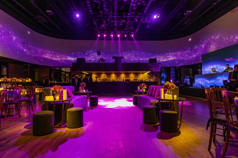 a purple lit room with a lot of seating