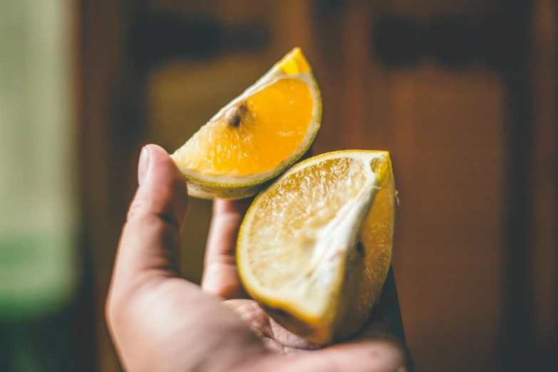 two halves of a lemon being held by someone