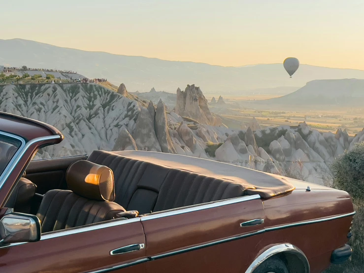 a car and a  air balloon flying in the sky