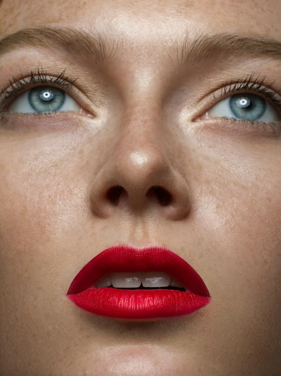 the eyes of a woman with bright red lipstick on her lips