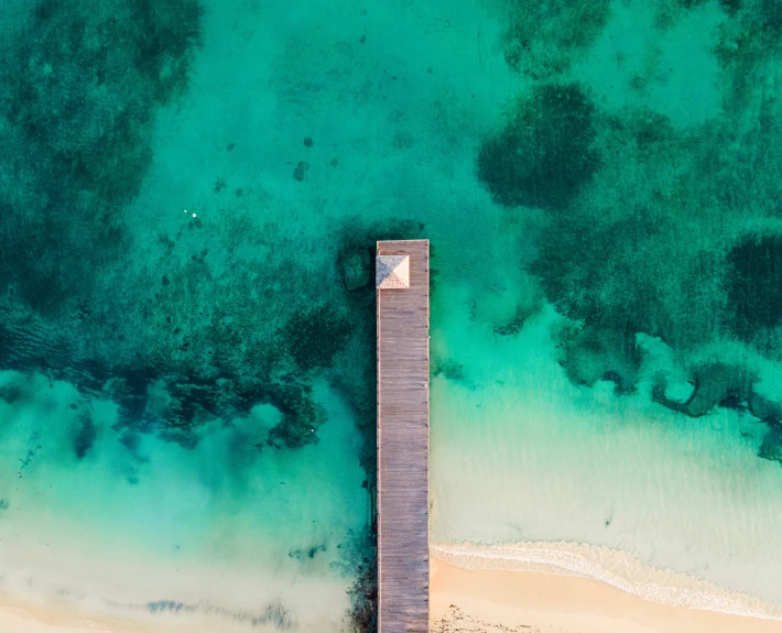 a small pier extending into the middle of the ocean