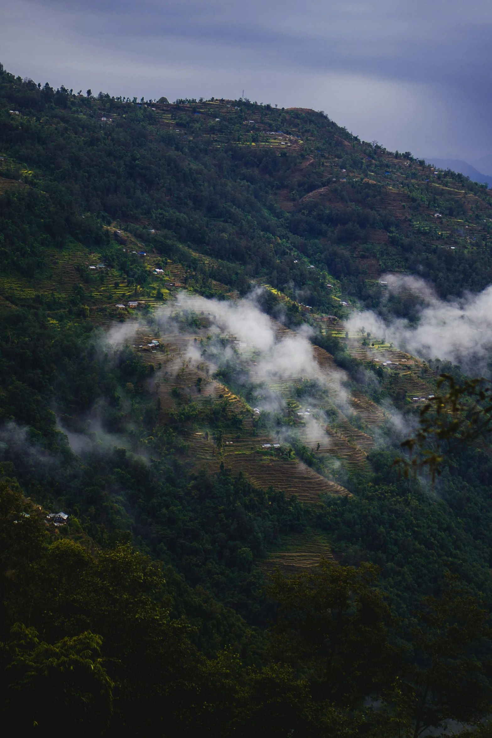 a large cloud hovers in front of a mountain