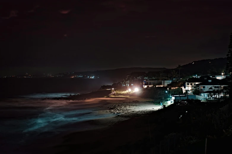 the beach is crowded with people in the dark