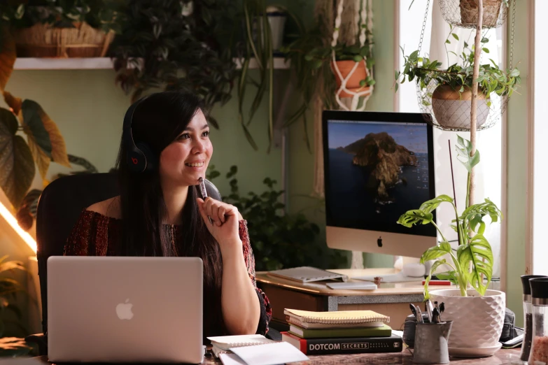 a woman wearing headphones using a laptop computer while listening to music on her headset