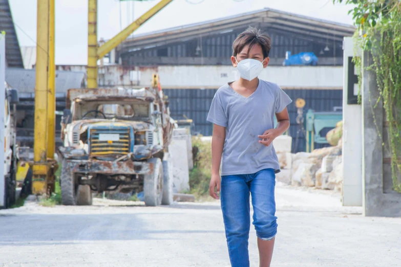 a young man wearing a mask and walking down the street