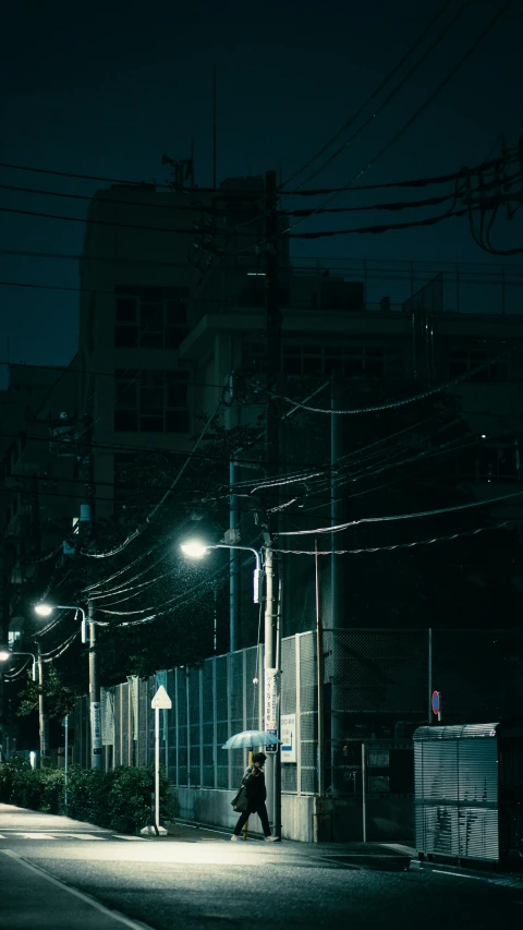 a man sitting on the street under a stoplight