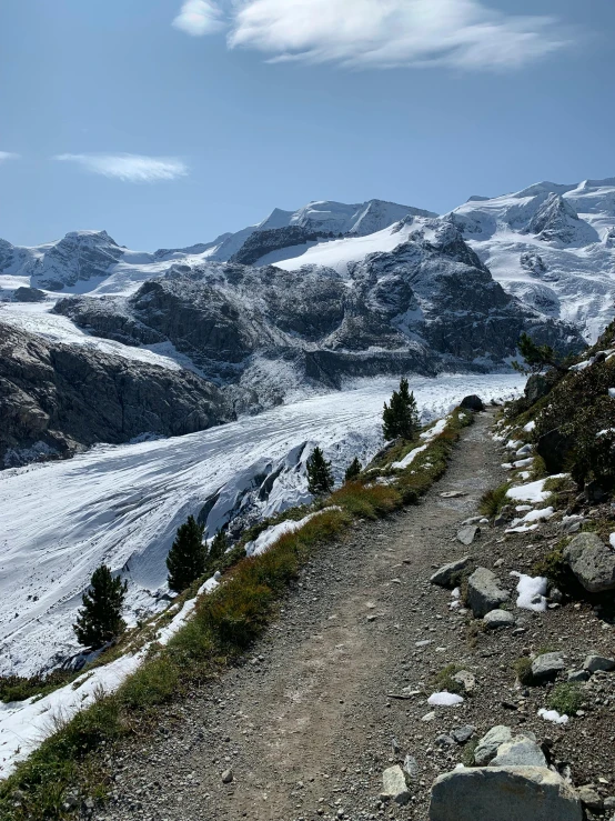 a trail leading to some very pretty snow covered mountains