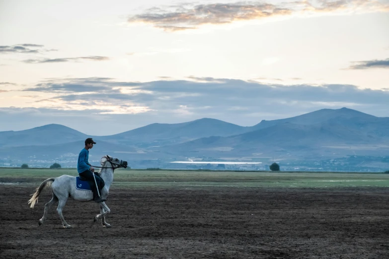 the man is riding his horse on the dirt field