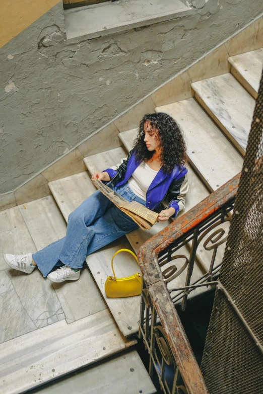 a woman sitting on steps with a book