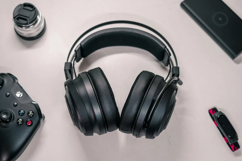 black headphones on table next to electronics