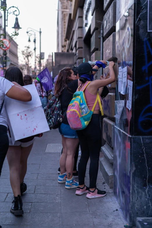 several women are standing in the alley on the street