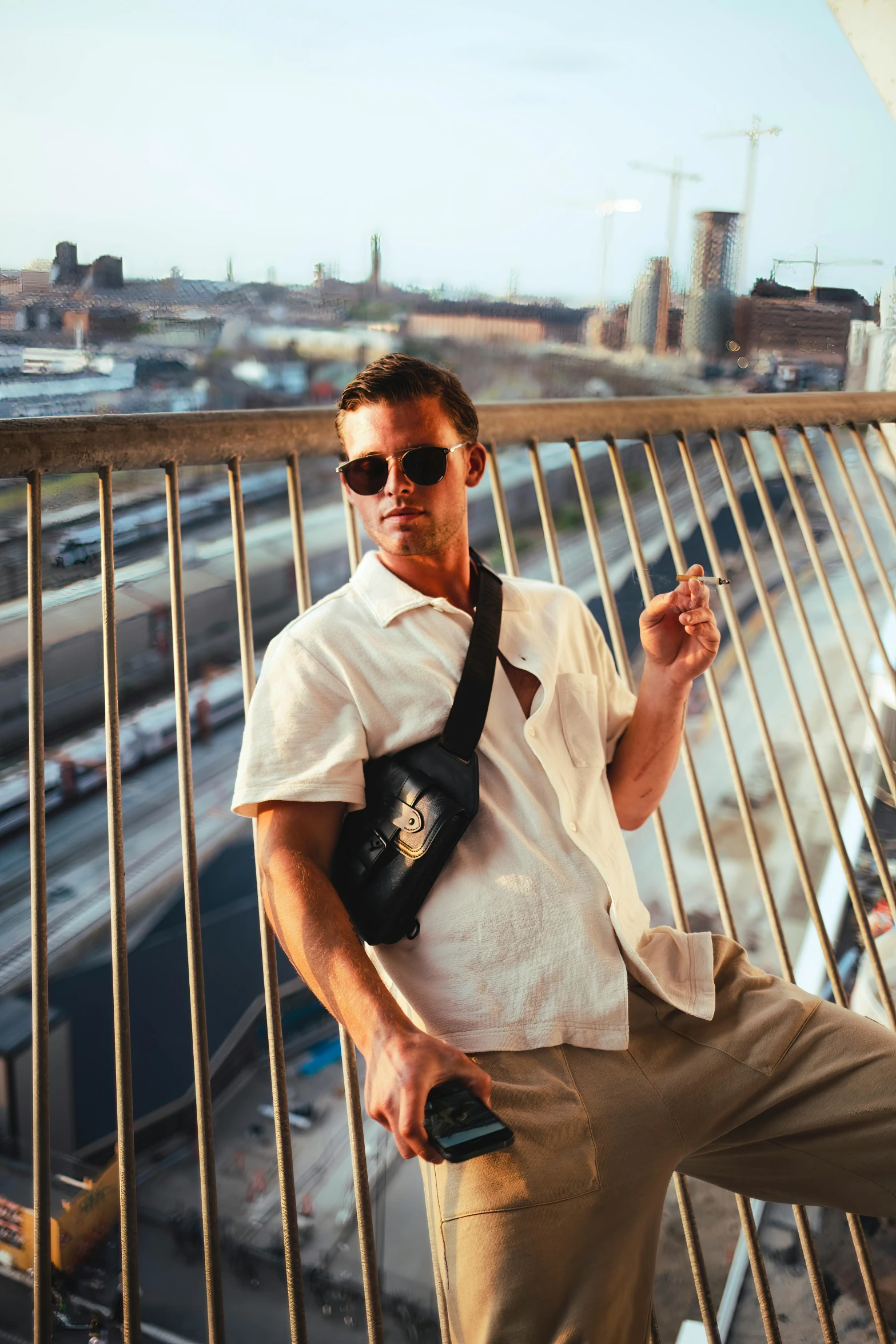 man with camera standing on rooftop and smoking cigarette