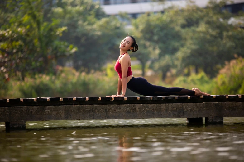 the girl is standing on the wooden bridge in a red bikini