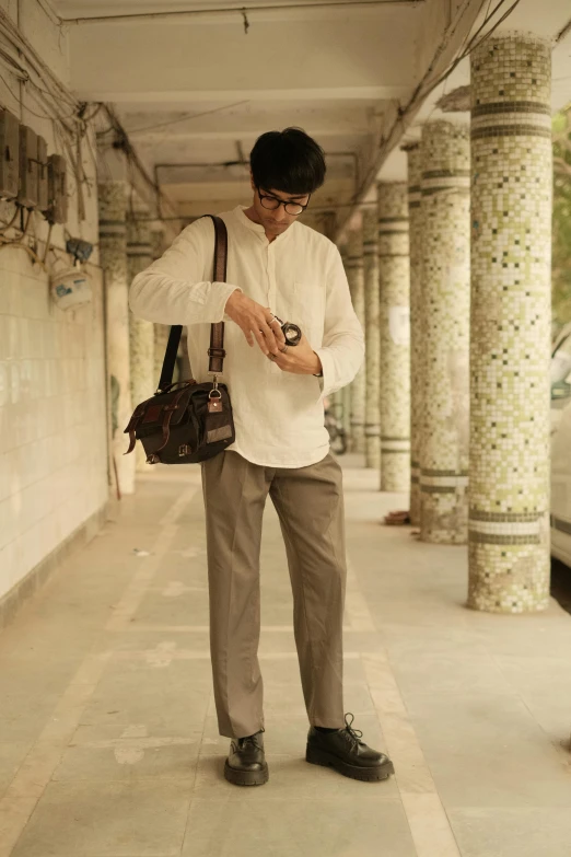 the young man in white shirt holding a brown bag