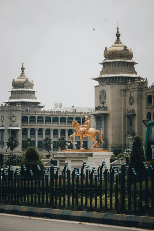 a very ornate building in front of a wrought fence