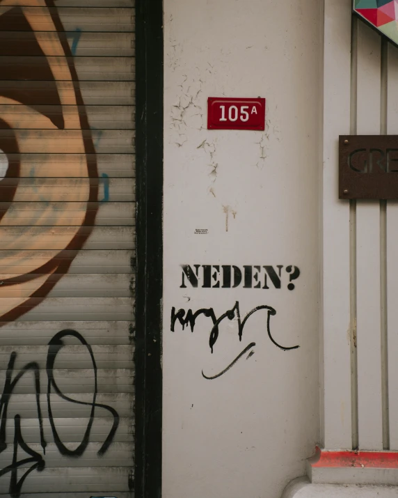 graffiti on a building door with a large red sign