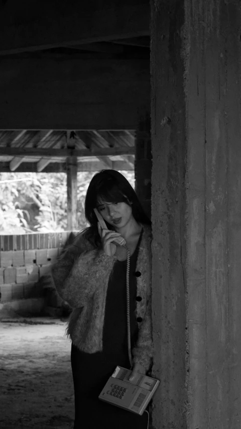 a woman standing in a room talking on her cell phone